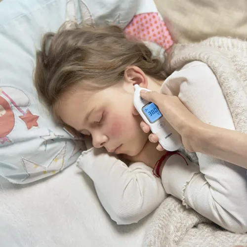 barn som sover där person tar tempen med Omron Gentle temp 533